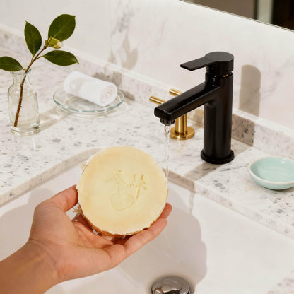 Holding a moisturizing silk soap bar at a bathroom sink — gentle cleansing soap for soft, balanced skin