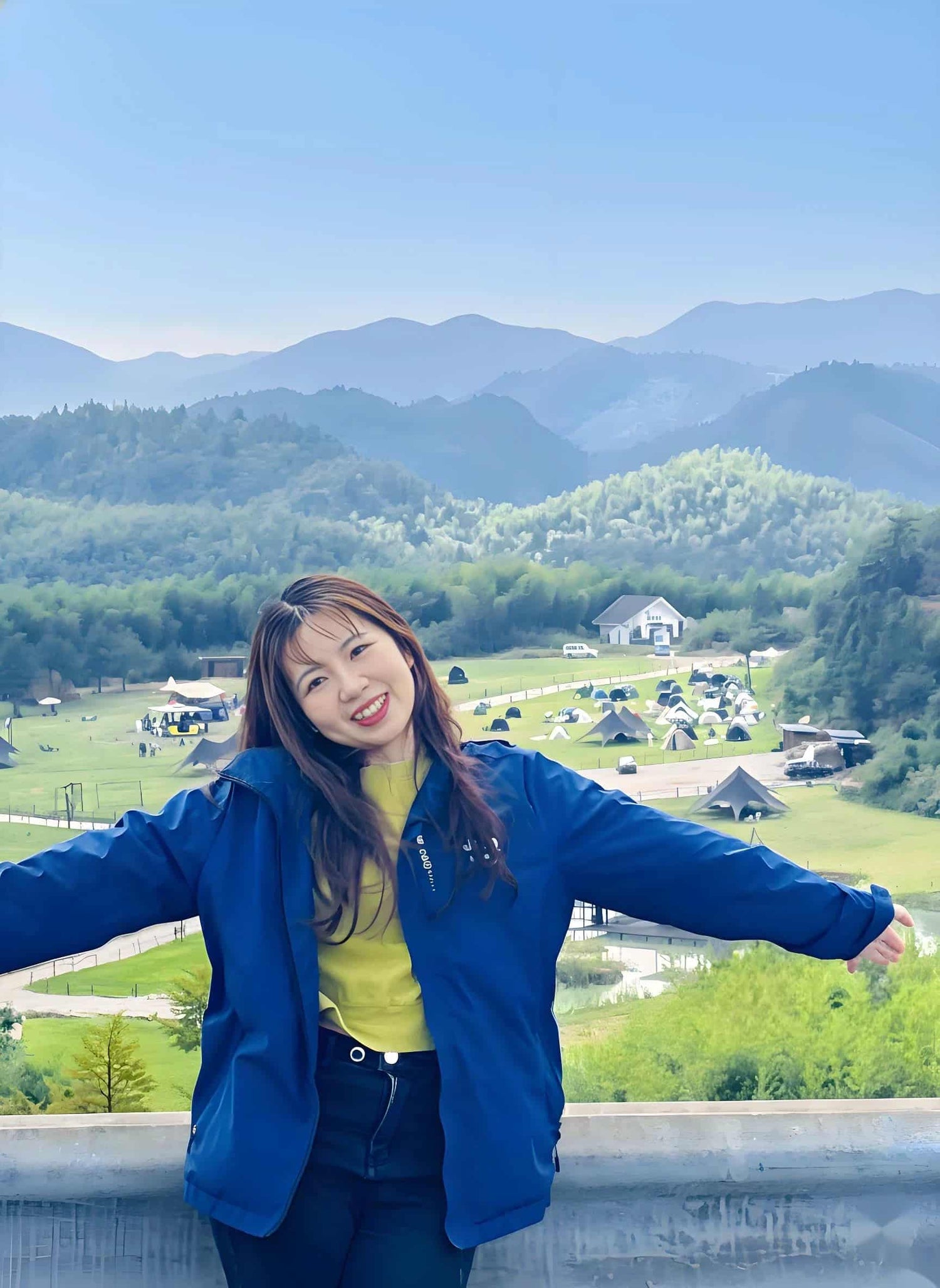 SootheHerbs natural living brand founder Bella Smith smiling in front of a sweeping green mountain landscape, sharing her passion for botanical wellness.