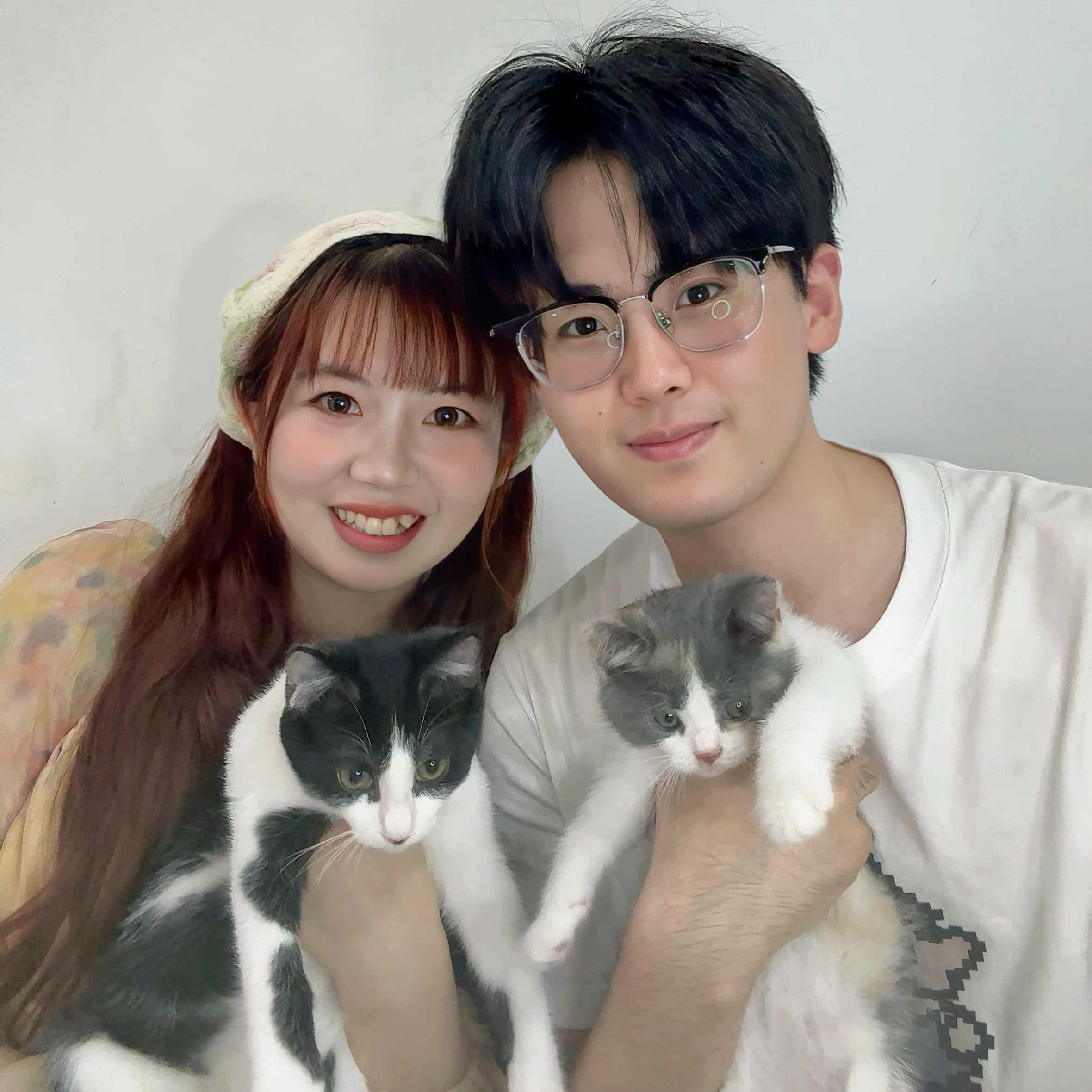 SootheHerbs team members Bella and Shawn holding their beloved studio cats Tu Tuan and Nomi, sharing a warm and authentic moment behind the natural beauty brand.
